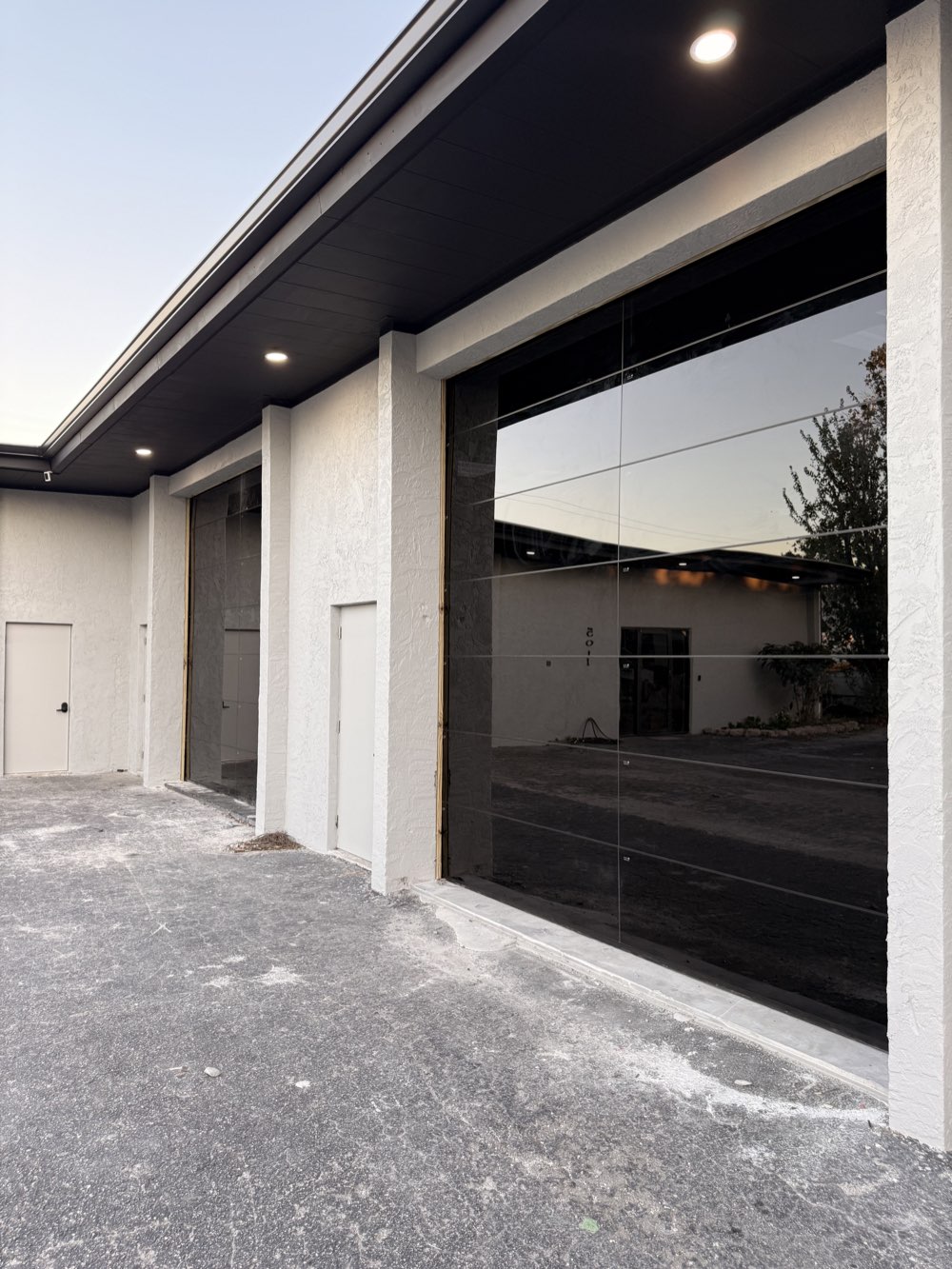 Full-view tinted glass garage doors on a modern commercial building