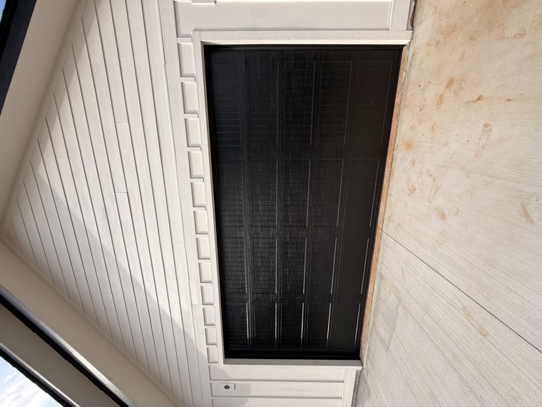 Black woodgrain long-panel garage door on a cream board-and-batten home in Spartanburg County, SC