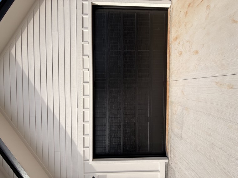 Front view of a black woodgrain long-panel double garage door installed on a new home in the Upstate SC