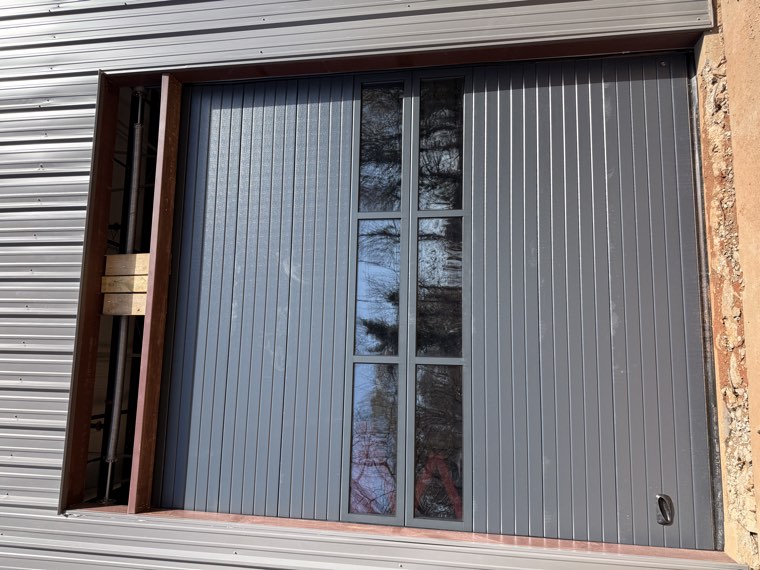 Charcoal commercial garage door with two rows of glass installed in a metal building in Spartanburg, SC