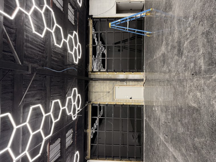 Interior of a commercial shop with two large black full-view glass garage doors