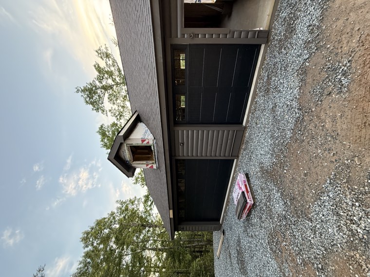 Detached three-car garage with dark brown carriage-style garage doors at sunset in the Upstate of South Carolina