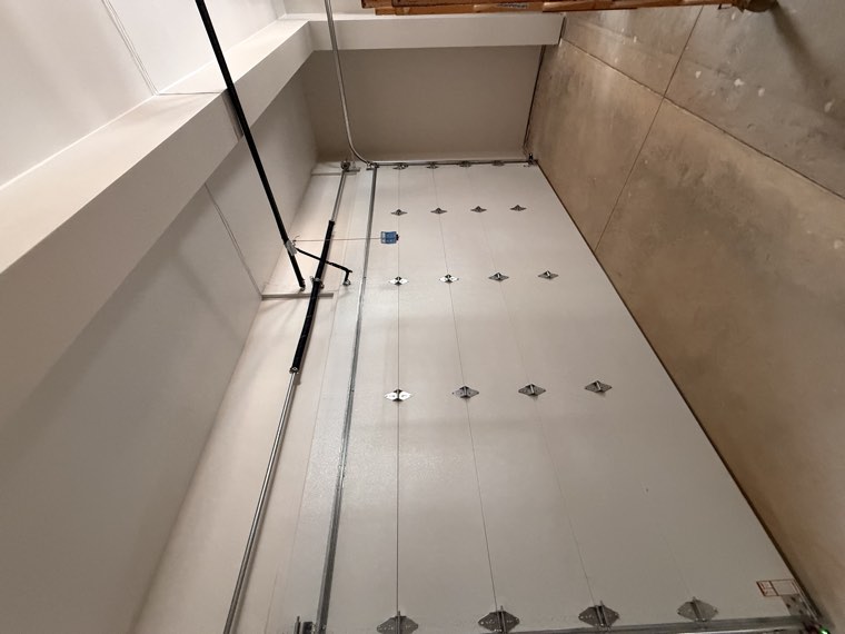 Interior view of a white insulated garage door with struts and rollers after installation