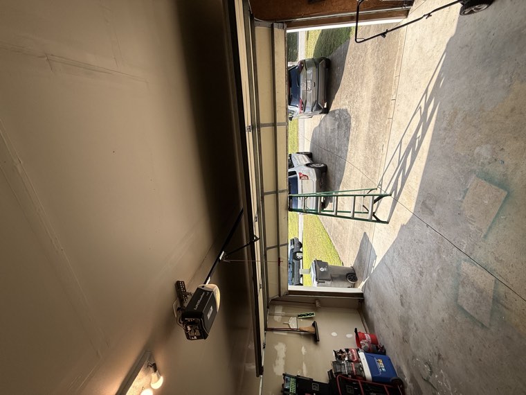 New garage door opener and rail installed in a home garage with the door open