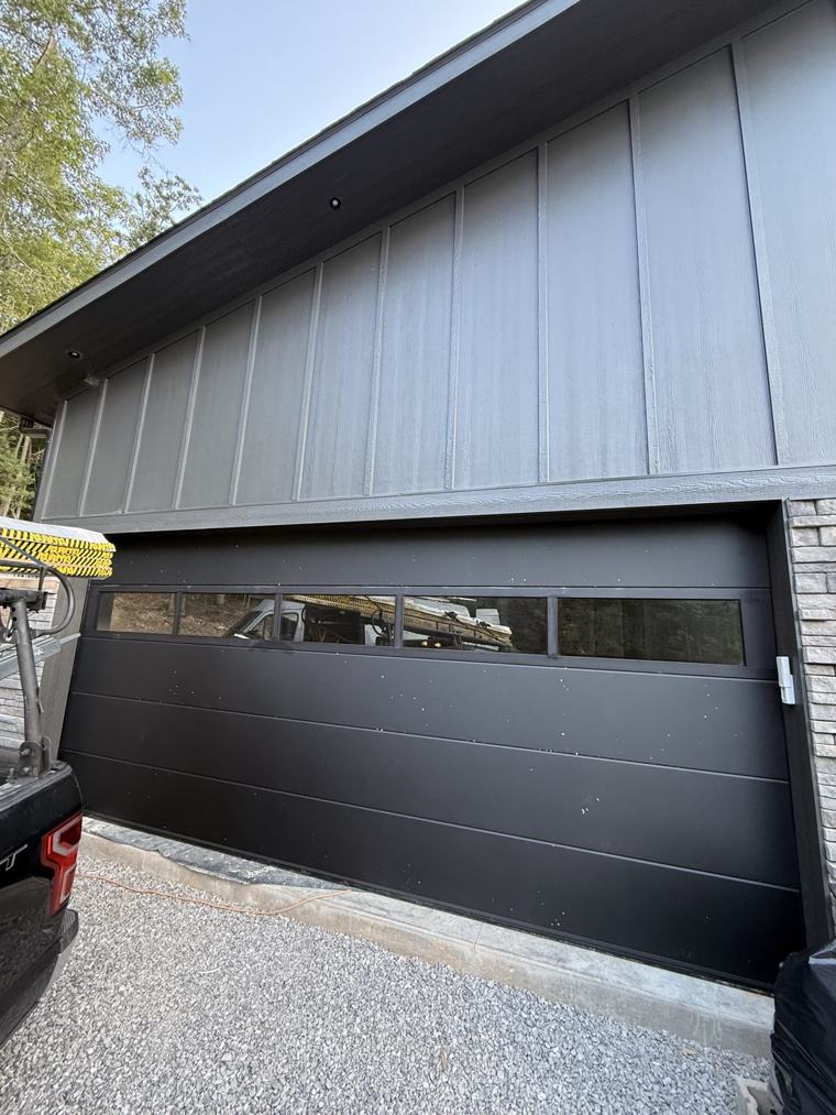 Matte black flush door with full-view glass top section, front view — installed by Viking Garage Door, Upstate SC