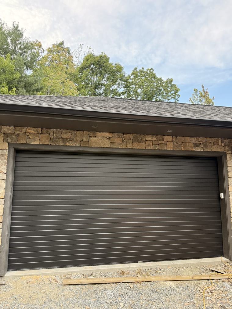 Black ribbed modern garage door on a stone home — installed by Viking Garage Door, Upstate SC