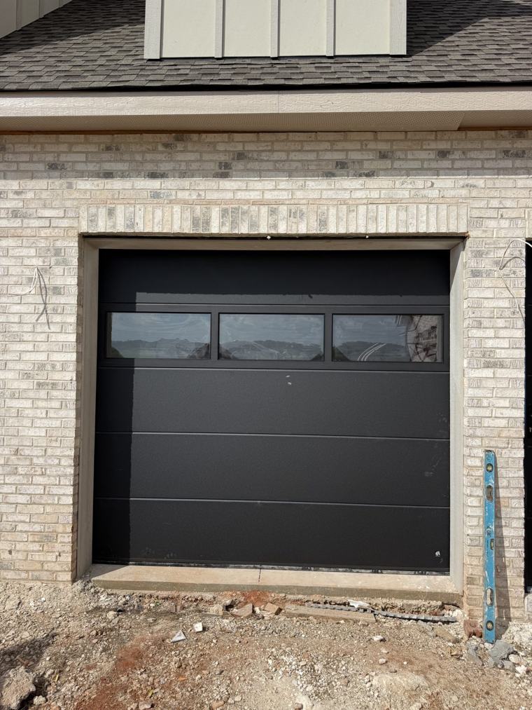 Single 9×8 matte black door with glass top section on a brick home — installed by Viking Garage Door, Upstate SC