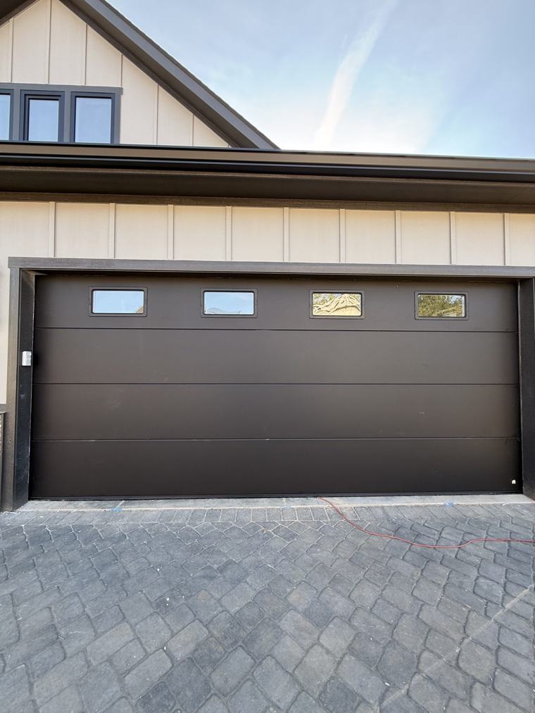 Matte black flush double door with four windows, front view — installed by Viking Garage Door, Upstate SC