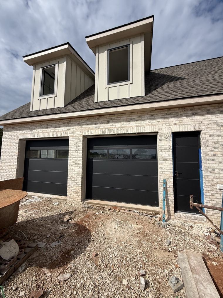 Two single matte black doors with glass top sections — installed by Viking Garage Door, Upstate SC